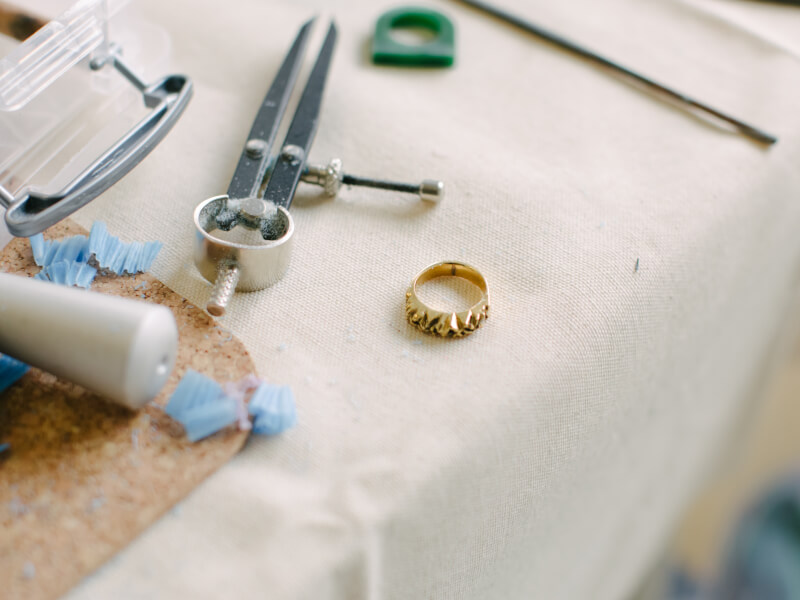 Chunky ring resting on table next to silvermithing tools